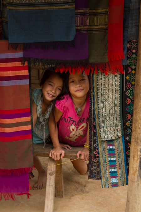Children peeking out from behind the scarves